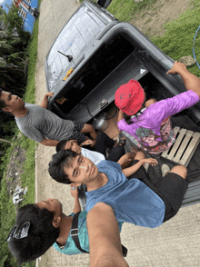 a group of people are sitting in the back of a truck with one wearing a shirt that says ' a ' on the back