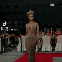 a tiktok video of a woman walking down a red carpet with the caption missgrandthailand