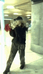 a woman wearing a black hat and pants is standing on a tiled floor