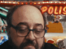 a close up of a man 's face with a sign in the background that says polis