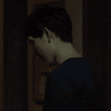 a man in a dark room looks at the camera with his mouth open