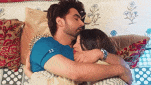 a man and a woman are hugging on a bed .