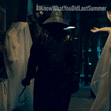 a man holding a hook in front of a sign that says iknowwhatyou didlastsummer