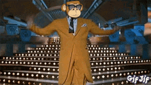 a gif of a monkey in a suit dancing on a stage