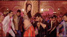a group of people are dancing in front of a sign that says e02