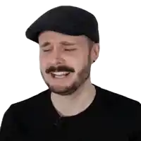 a man with a beard wearing a flat cap is crying with his eyes closed