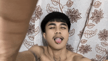 a shirtless man is taking a selfie with his tongue out
