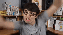 a man wearing glasses is making a funny face in front of a shelf with a sign that says " exist or go "
