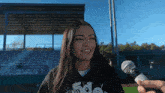 a woman wearing a shirt that says sdg is being interviewed by a person holding a microphone