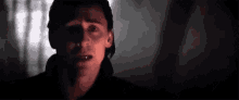 a close up of a man 's face in the dark with a shadow on his face .