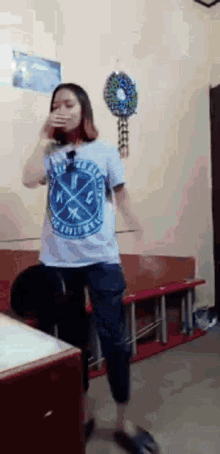 a girl wearing a t-shirt that says ' freedom ' on it is dancing in a room