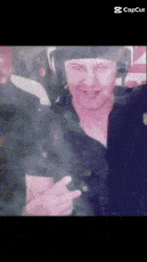 a man wearing headphones and a hat is giving a peace sign