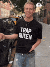 a man wearing a black trap queen t-shirt
