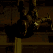 a man in a black jacket is flying through the air in a dark room .
