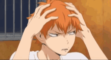 a person with orange hair is holding their head in their hands