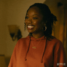 a woman wearing a red hoodie with a necklace that says daddy