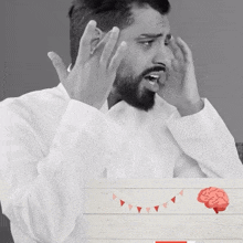 a black and white photo of a man with his hands on his head