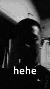 a black and white photo of a man 's face with the words ` ` he he ` ` written on it .