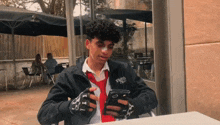 a young man with a bandage on his face is looking at his cell phone