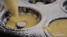 powdered sugar is being poured into a pan with the words made in animotica below it