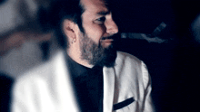 a man with a beard wearing a white jacket