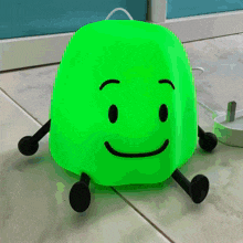 a green toy with a face and arms and legs