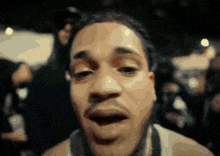 a blurry image of a man 's face with a crowd in the background
