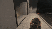 a hand is holding a coca cola bottle in a hallway