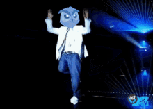 a man in a white suit with an owl on his head stands in front of a mtv sign