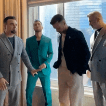 a group of men are standing in front of a window