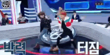 a group of people are dancing on a stage with a sign that says 360 on it .
