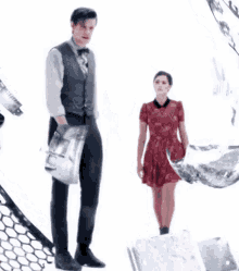 a man and a woman are holding hands while standing in front of a white background