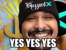 a man with a beard wearing a black beanie that says blazzard on it