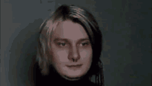 a close up of a man 's face with long blonde hair and a nose ring