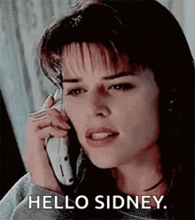 a woman is talking on a cell phone with the words `` hello sidney '' written on the bottom .