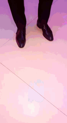 a person 's feet are shown on a pink floor
