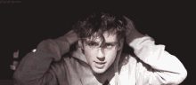 a young man with curly hair is wearing a hoodie .