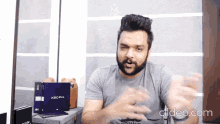 a man with a beard is talking in front of a xbo pro laptop