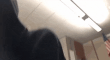 a person is standing in a room with a ceiling light on .