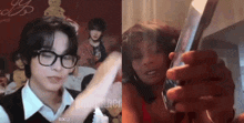 a man wearing glasses and a woman wearing a red dress are holding a cell phone .