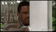 a man is peeking out from behind a white pole and saying `` i see you '' .