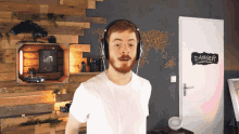 a man wearing headphones is standing in front of a door that says danger