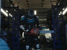 a man in a superhero costume is holding a chainsaw in his hand
