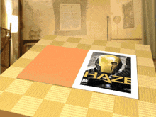 a poster for haze is sitting on a checkered table cloth