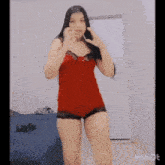 a woman in a red bodysuit is dancing in front of a white wall with inshot written on the bottom