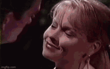 a man and a woman are looking at each other . the woman is smiling and the man is looking at her .