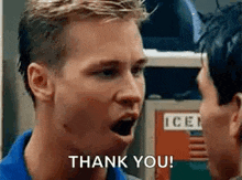 a man is talking to another man with his mouth open and saying `` thank you '' .