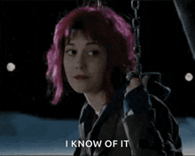 a woman with pink hair is sitting on a swing and saying i know of it .
