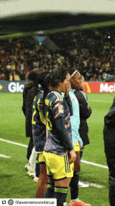a group of women standing on a soccer field with one wearing a number 22 jersey