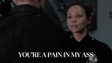 a woman in a police uniform says " you 're a pain in my ass " to a man in a black jacket